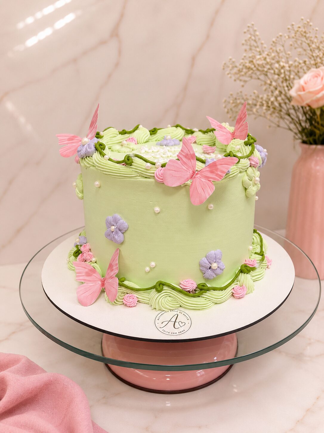 Bolo redondo verde com borboletas decorativas