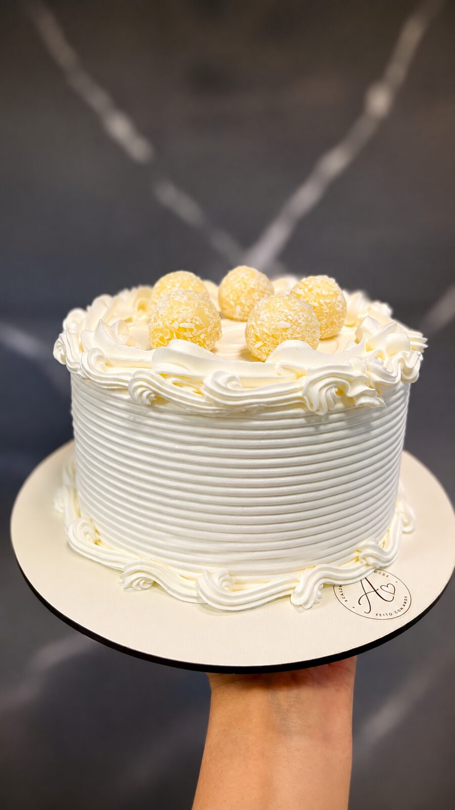 Bolo de aniversário dourado com esferas e flores